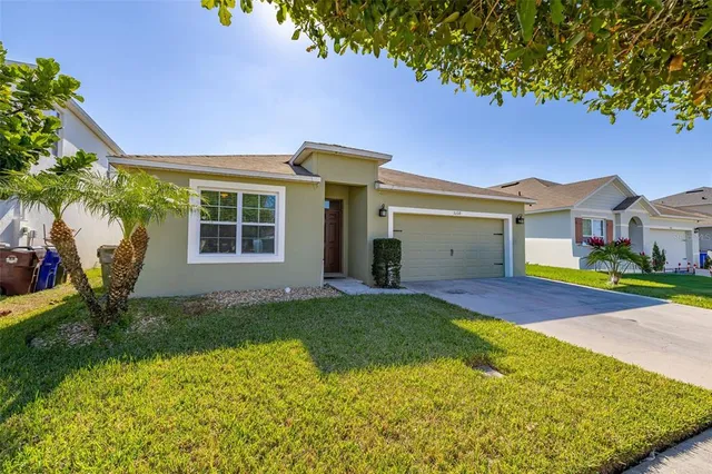 a view of house with backyard and a tree
