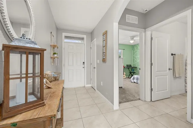 a view of a hallway with wooden floor and a bathroom
