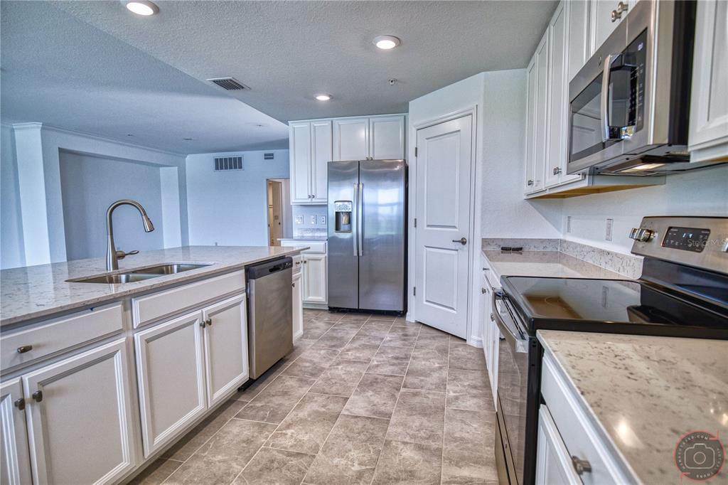 12355 Ghiberti Circle, Unit 101 Venice, FL 34293 - Photo 13 of 41 a kitchen with stainless steel appliances granite countertop a sink stove and refrigerator