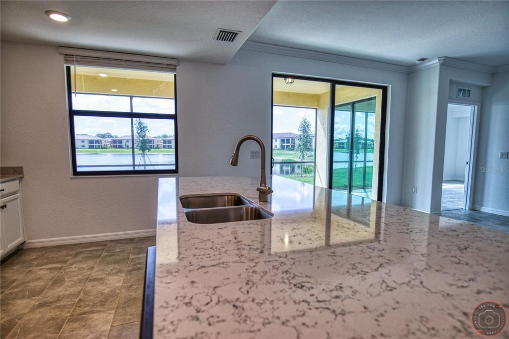 12355 Ghiberti Circle, Unit 101 Venice, FL 34293 - Photo 15 of 41 a kitchen with granite countertop a sink and a window