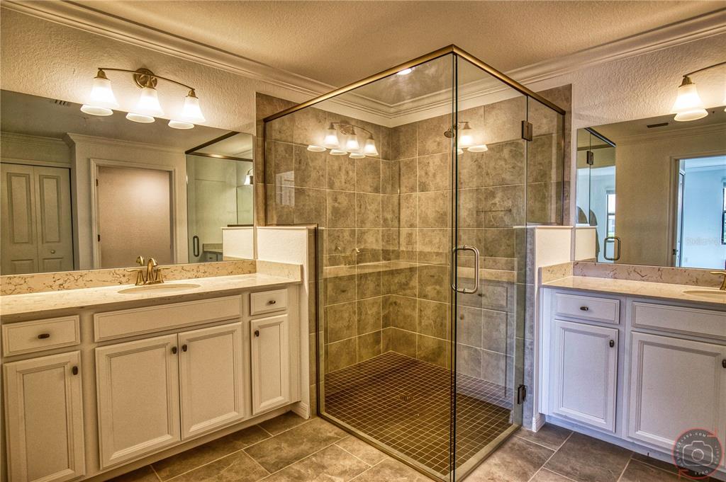 12355 Ghiberti Circle, Unit 101 Venice, FL 34293 - Photo 26 of 41 a bathroom with a shower sink and mirror