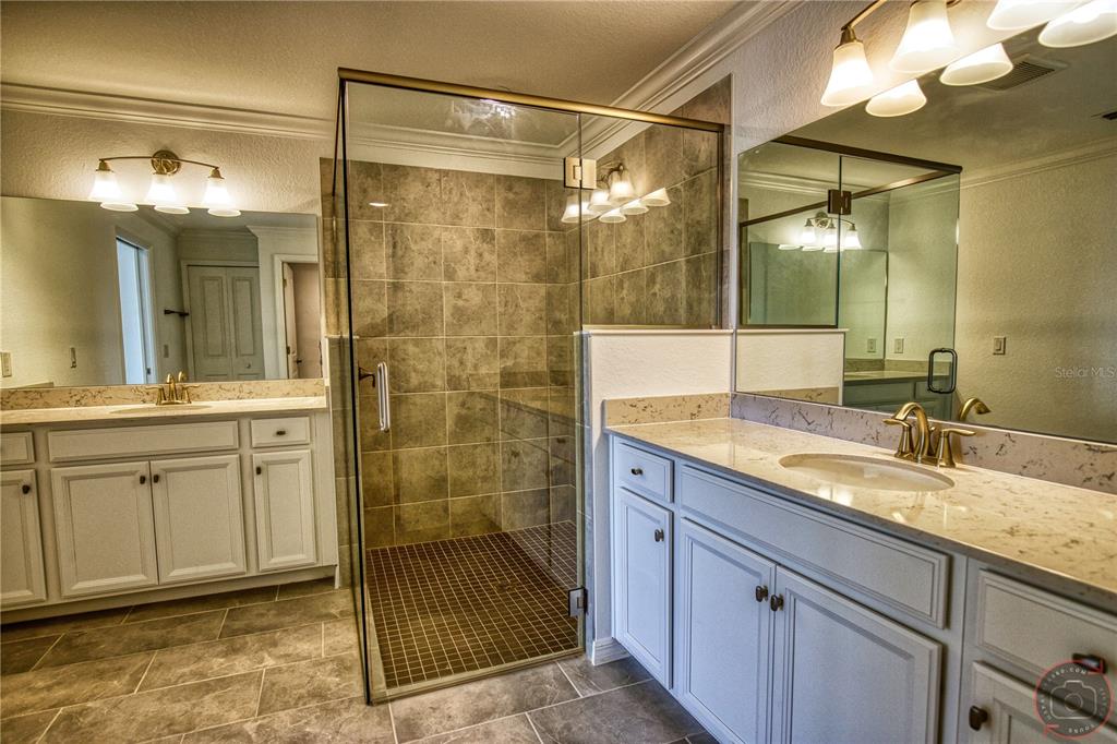 12355 Ghiberti Circle, Unit 101 Venice, FL 34293 - Photo 27 of 41 a bathroom with a shower sink and mirror