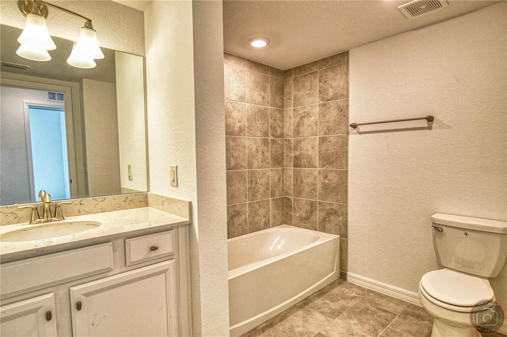 12355 Ghiberti Circle, Unit 101 Venice, FL 34293 - Photo 30 of 41 a bathroom with a sink a toilet and shower