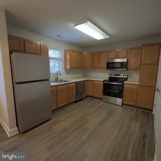 a kitchen with wooden cabinets and stainless steel appliances