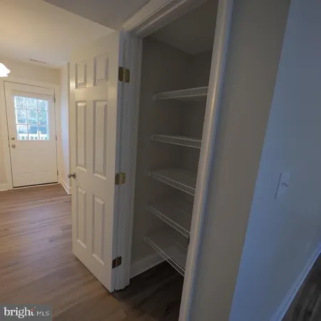 a view of a hallway with wooden floor and closet