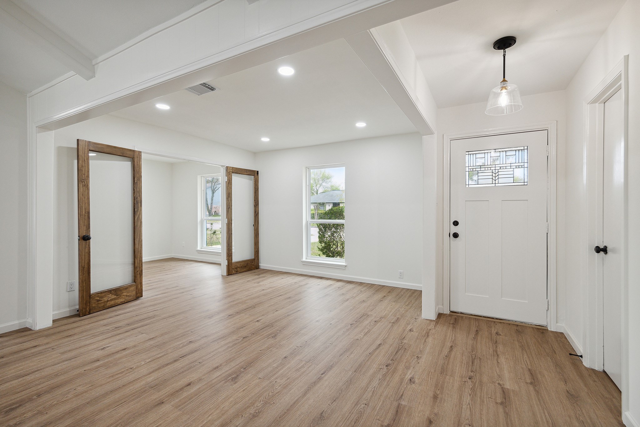 9719 Springmont Drive Houston, TX 77080 - Photo 5 of 32 WOW! So light and bright! The home offers an open-concept plan where spaces and light flow freely! Entrance with a gorgeous leaded-glass panel front door opens to formal dining and central living room! Glass French doors lead the way to a bonus room that can be a home office or FOURTH BEDROOM!!