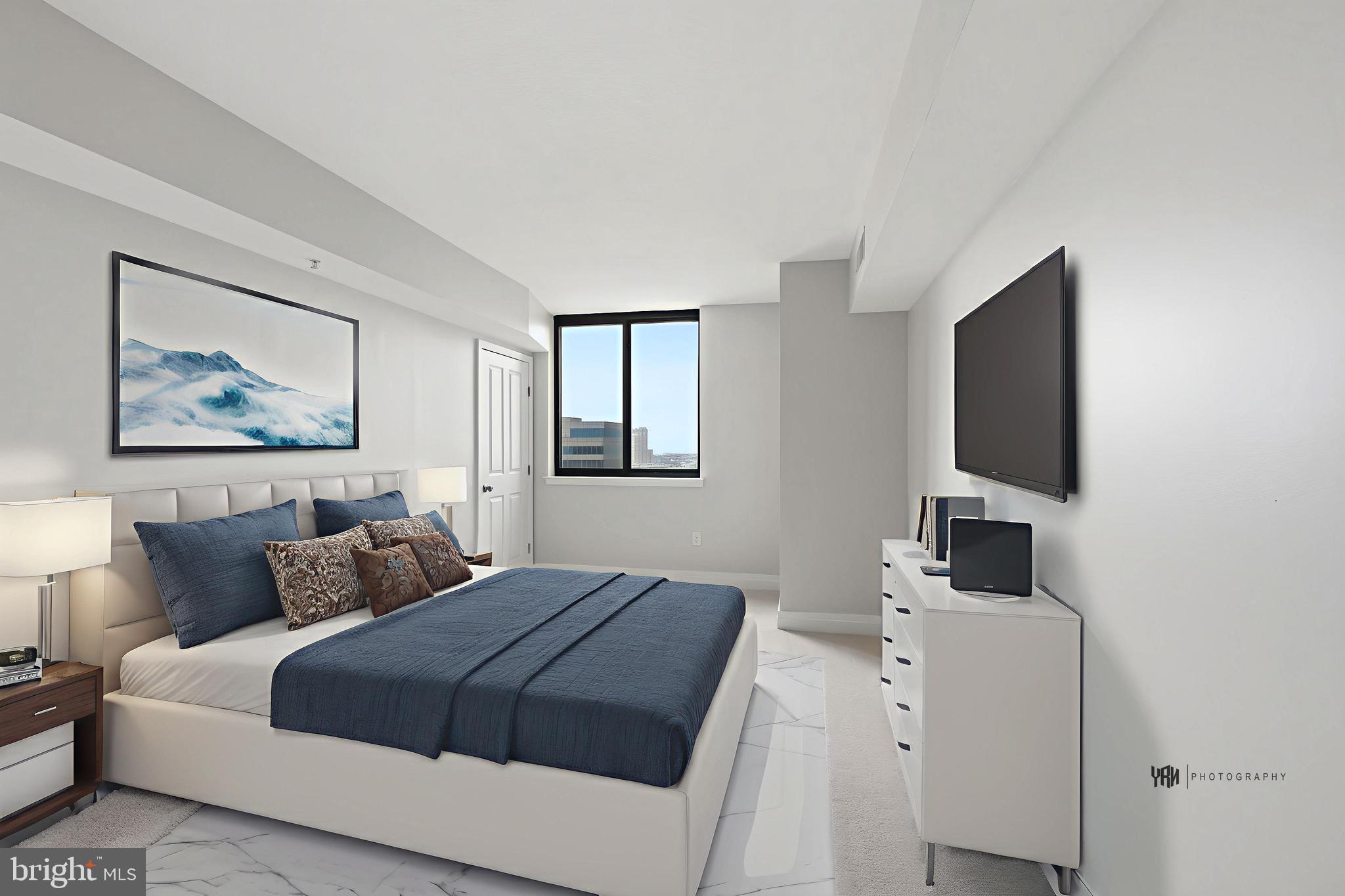 414 Water Street, Unit 1501 Baltimore, MD 21202 - Photo 13 of 21 a bedroom with a large bed and a flat screen tv