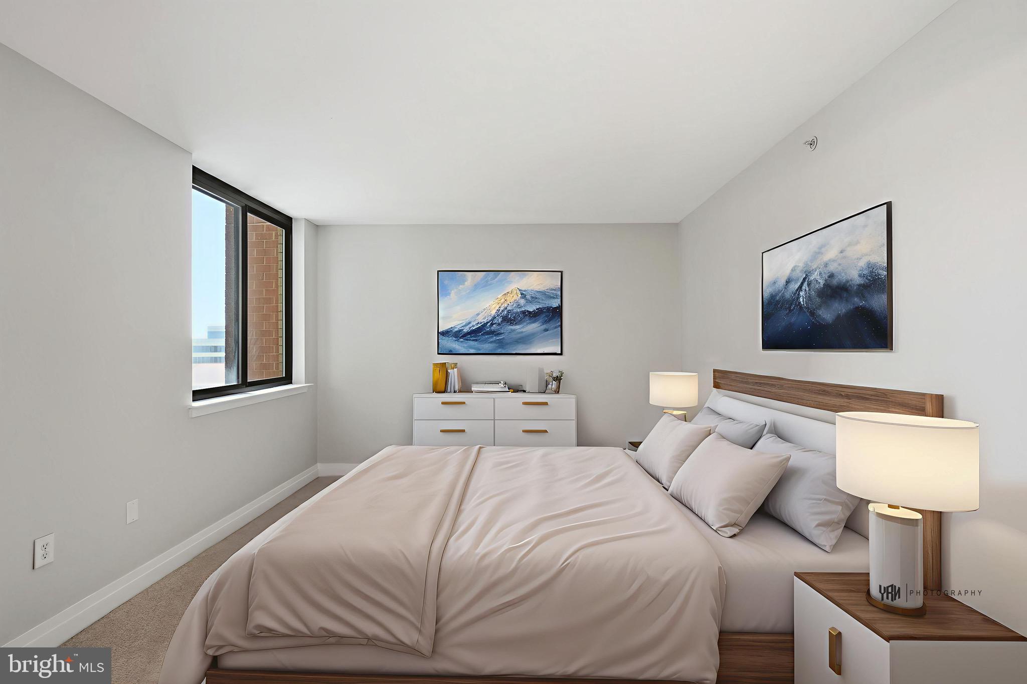 414 Water Street, Unit 1501 Baltimore, MD 21202 - Photo 16 of 21 a bedroom with a bed and a lamp on table