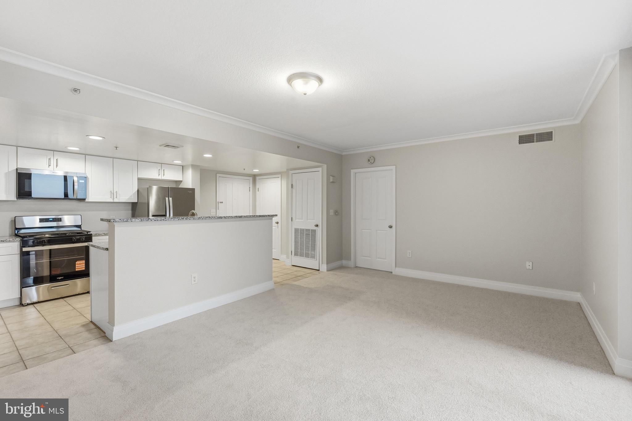 414 Water Street, Unit 1501 Baltimore, MD 21202 - Photo 9 of 21 a view of a kitchen with a sink stove and a refrigerator