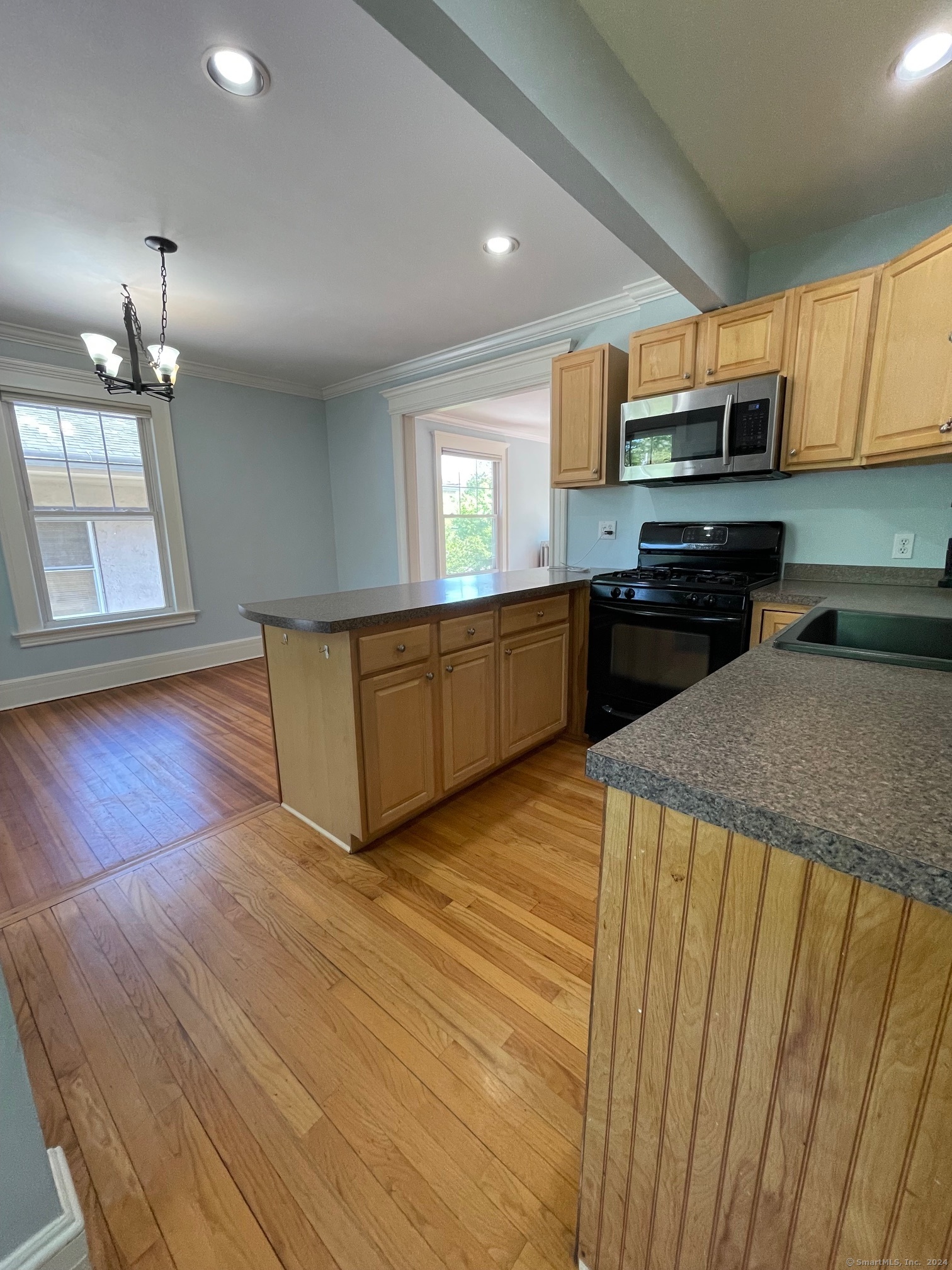 809 Edgewood Avenue, Unit 2 New Haven, CT 06515 - Photo 6 of 15 a kitchen with stainless steel appliances granite countertop a refrigerator a stove top oven a sink with dishwasher and wooden cabinets
