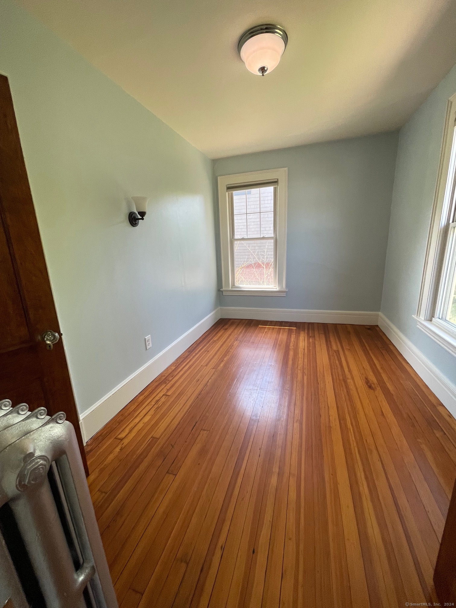 809 Edgewood Avenue, Unit 2 New Haven, CT 06515 - Photo 10 of 15 an empty room with wooden floor and windows