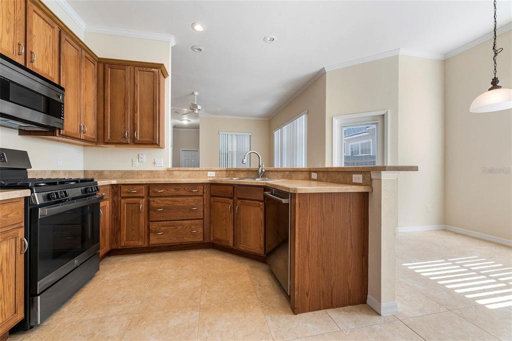 8668 Southwest 77th Avenue Gainesville, FL 32608 - Photo 12 of 29 a kitchen with stainless steel appliances granite countertop a stove a sink and a microwave