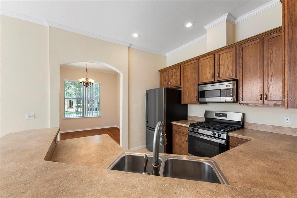 8668 Southwest 77th Avenue Gainesville, FL 32608 - Photo 13 of 29 a kitchen with granite countertop a refrigerator stove and microwave