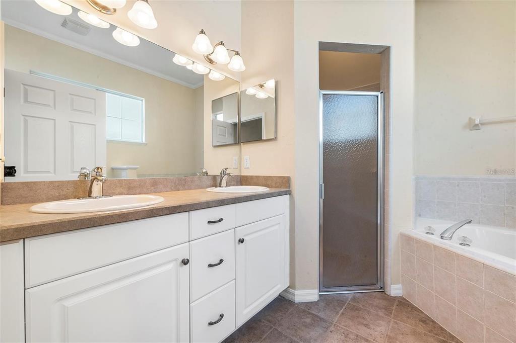 8668 Southwest 77th Avenue Gainesville, FL 32608 - Photo 23 of 29 a bathroom with a sink vanity tub and a mirror