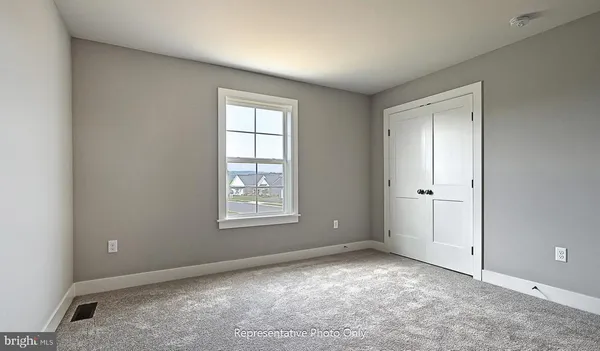 an empty room with windows and closet