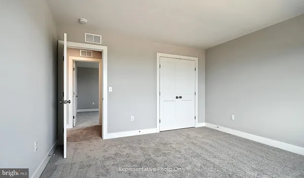 an empty room with closet and a bathroom