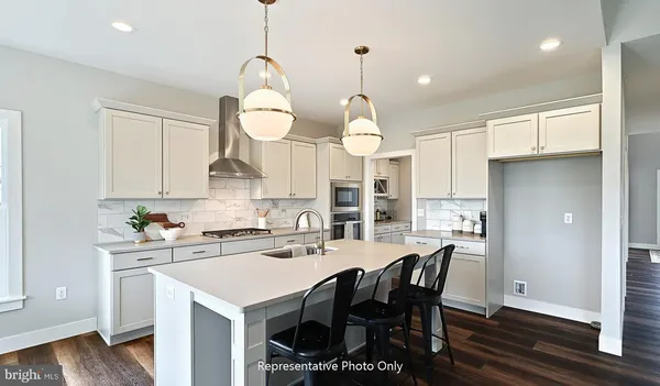 a kitchen with a dining table chairs sink and cabinets