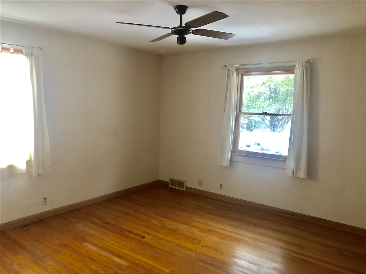 1511 Warren Road Rockford, IL 61108 - Photo 7 of 14 an empty room with wooden floor ceiling fan and windows