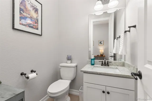 a kitchen with stainless steel appliances kitchen island granite countertop a refrigerator a stove a sink dishwasher and white cabinets with wooden floor