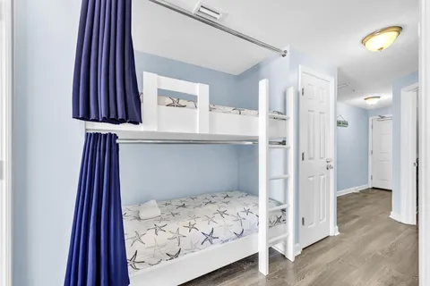 a bedroom with a bed and a lamp on a dresser