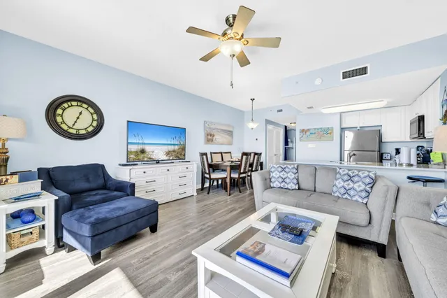 a living room with furniture a clock on wall and a table