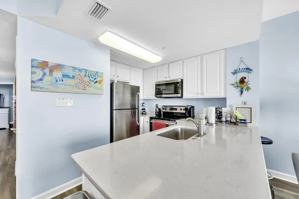 a kitchen with stainless steel appliances a refrigerator stove microwave and sink