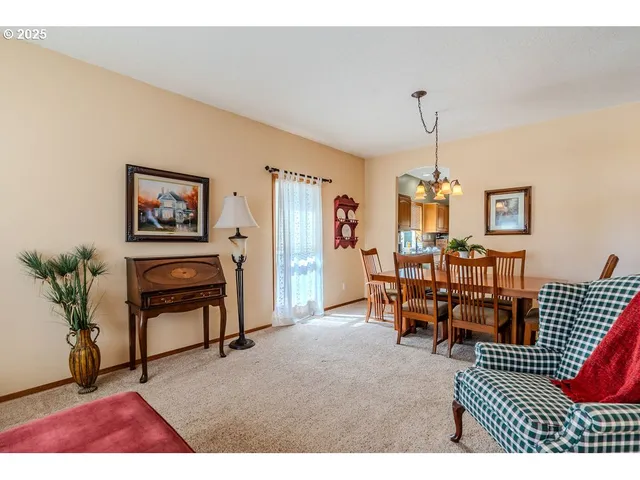 a view of a dining room and livingroom with furniture wooden floor a chandelier