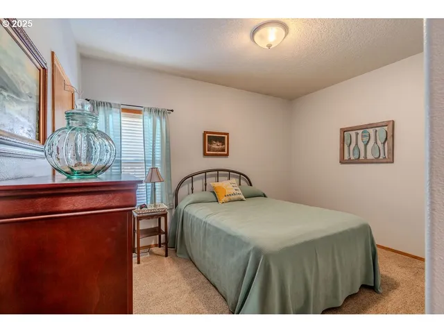 a bedroom with a bed and a painting on the wall