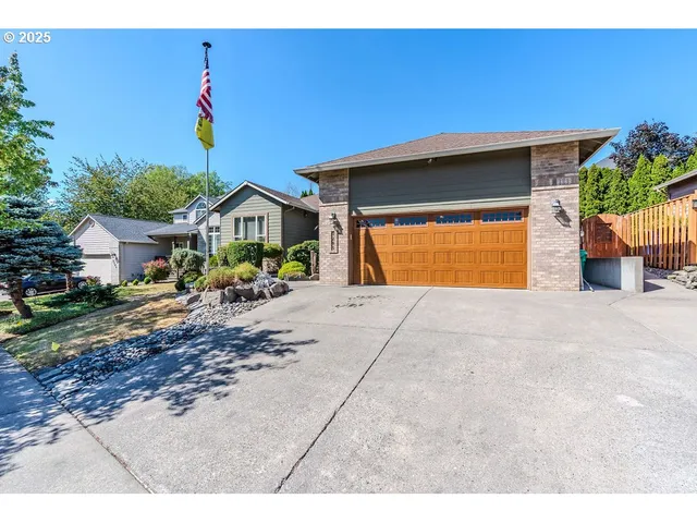a front view of a house with a yard and potted plants