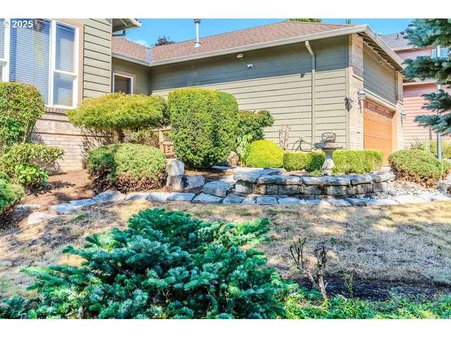 a view of a backyard with plants and chairs