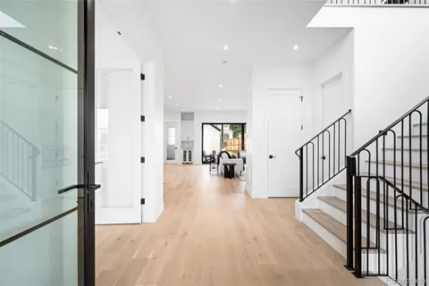 a view of a hallway with wooden floor and a living room