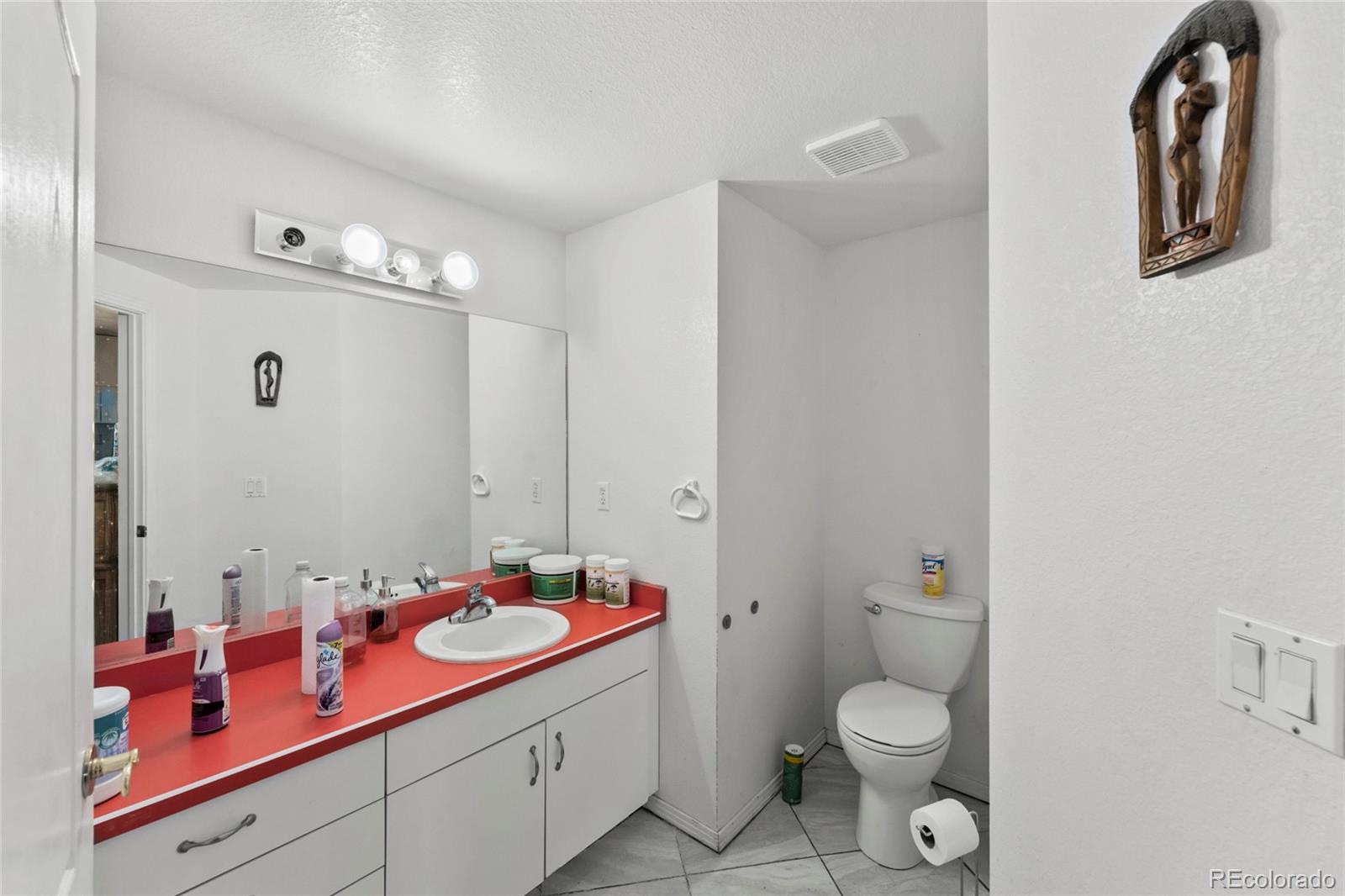 16575 Roller Coaster Road Colorado Springs, CO 80921 - Photo 11 of 26 a bathroom with a granite countertop sink mirror vanity and toilet