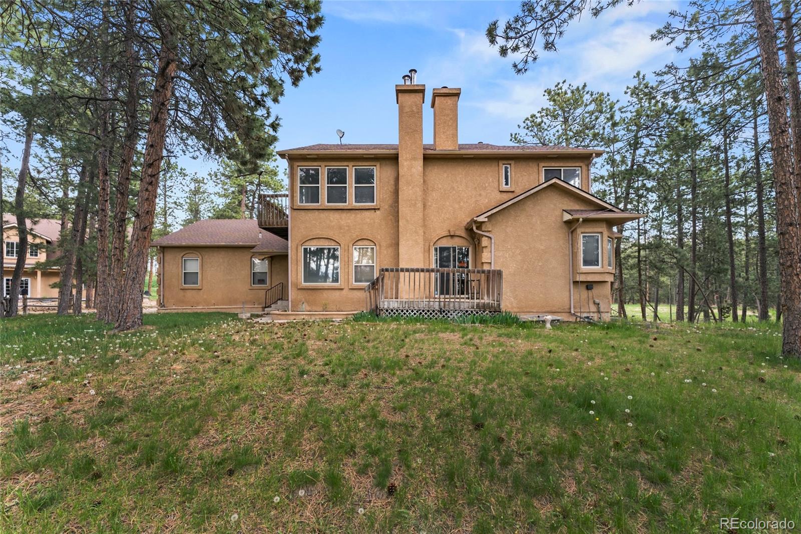 16575 Roller Coaster Road Colorado Springs, CO 80921 - Photo 24 of 26 a view of a house with a yard and large trees