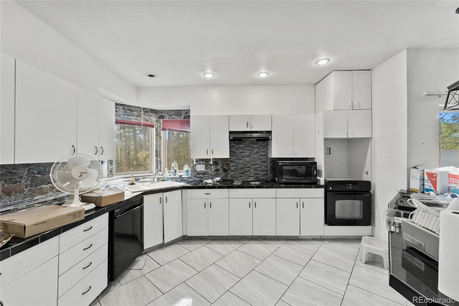 16575 Roller Coaster Road Colorado Springs, CO 80921 - Photo 6 of 26 a kitchen with granite countertop a sink stove top oven and cabinets