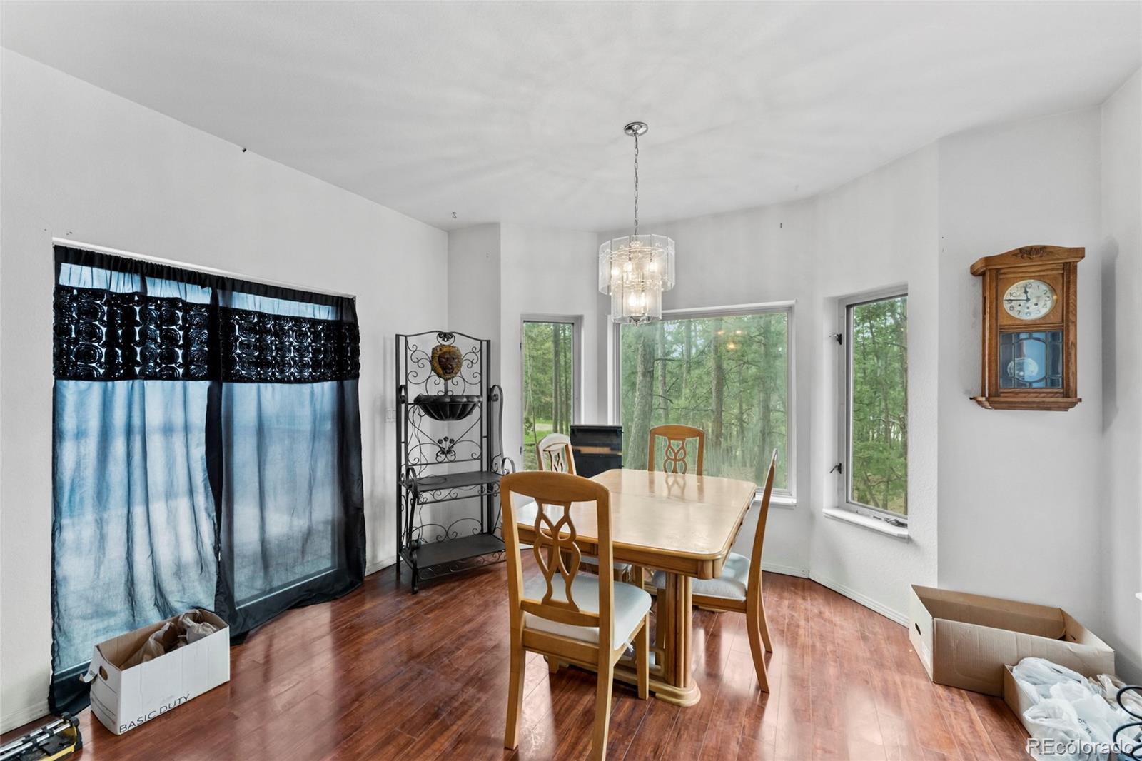 16575 Roller Coaster Road Colorado Springs, CO 80921 - Photo 7 of 26 a view of a dining room with furniture window and wooden floor