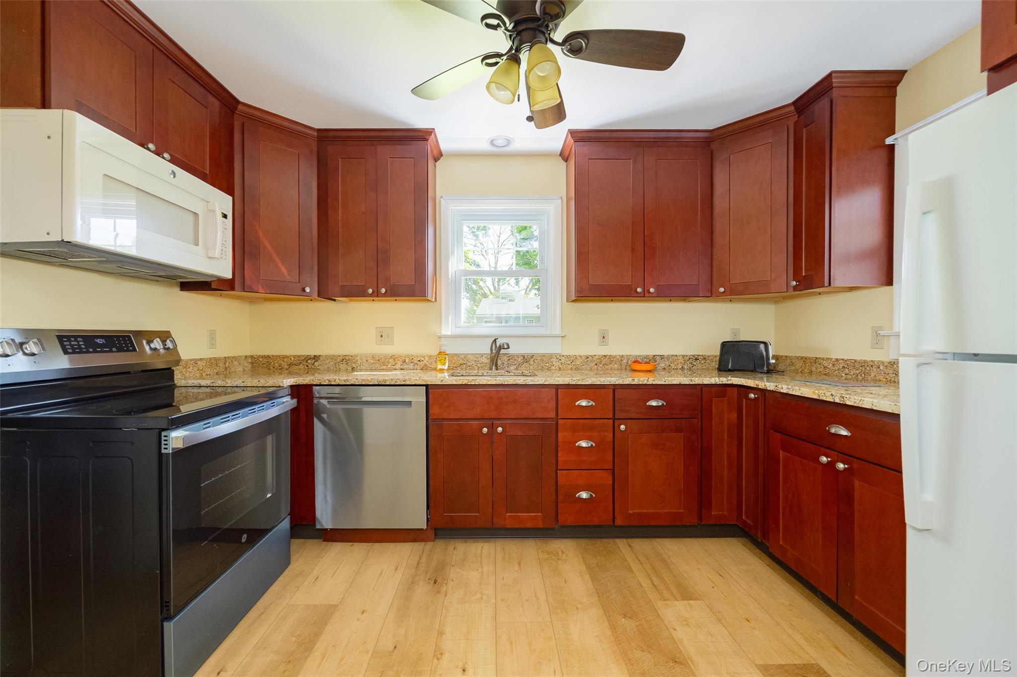 30 Marple Road Poughkeepsie, NY 12603 - Photo 14 of 26 Kitchen featuring wood-finish flooring, cherry-stained cabinetry, light-colored granite countertops, and a full suite of appliances