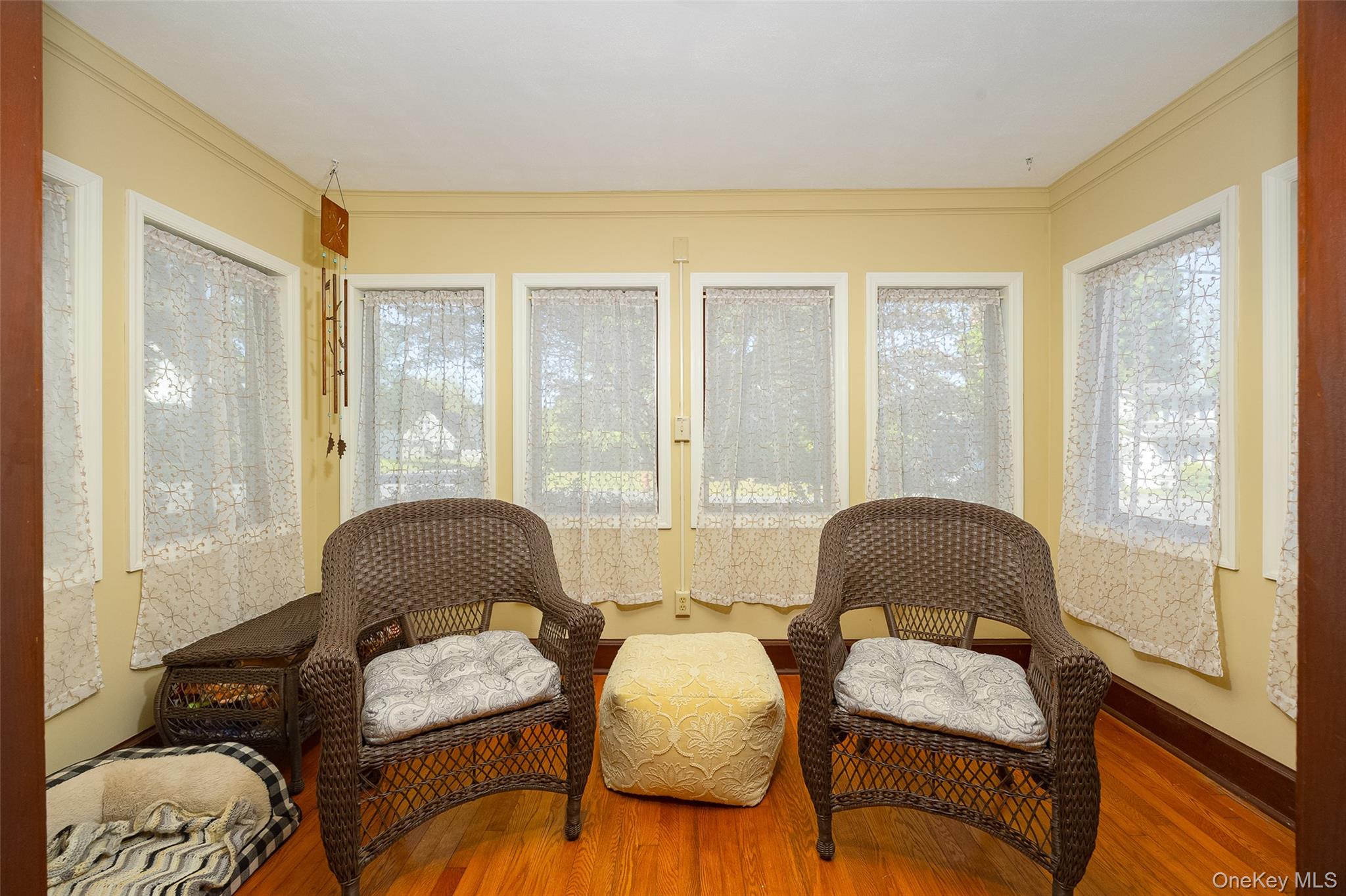 30 Marple Road Poughkeepsie, NY 12603 - Photo 10 of 26 Sun-drenched room featuring multiple windows, warm yellow wall paint, hardwood flooring, white window trim, and dark wood baseboards