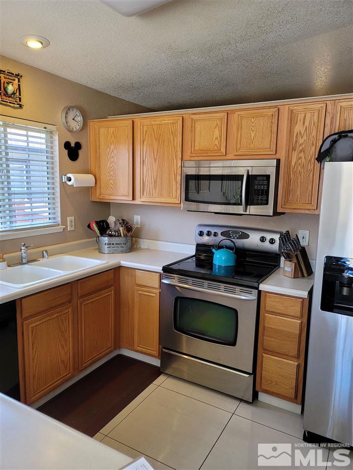 17756 Fortune Court Reno, NV 89508 - Photo 26 of 28 a kitchen with stainless steel appliances a stove microwave and sink