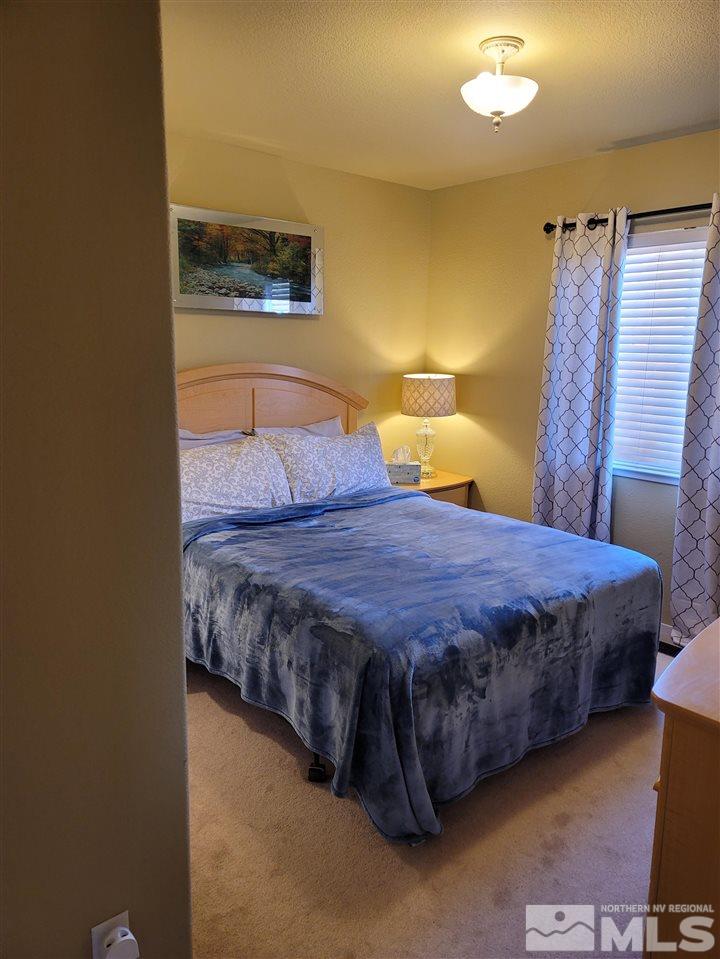 17756 Fortune Court Reno, NV 89508 - Photo 27 of 28 a spacious bedroom with a bed and a lamp on the table