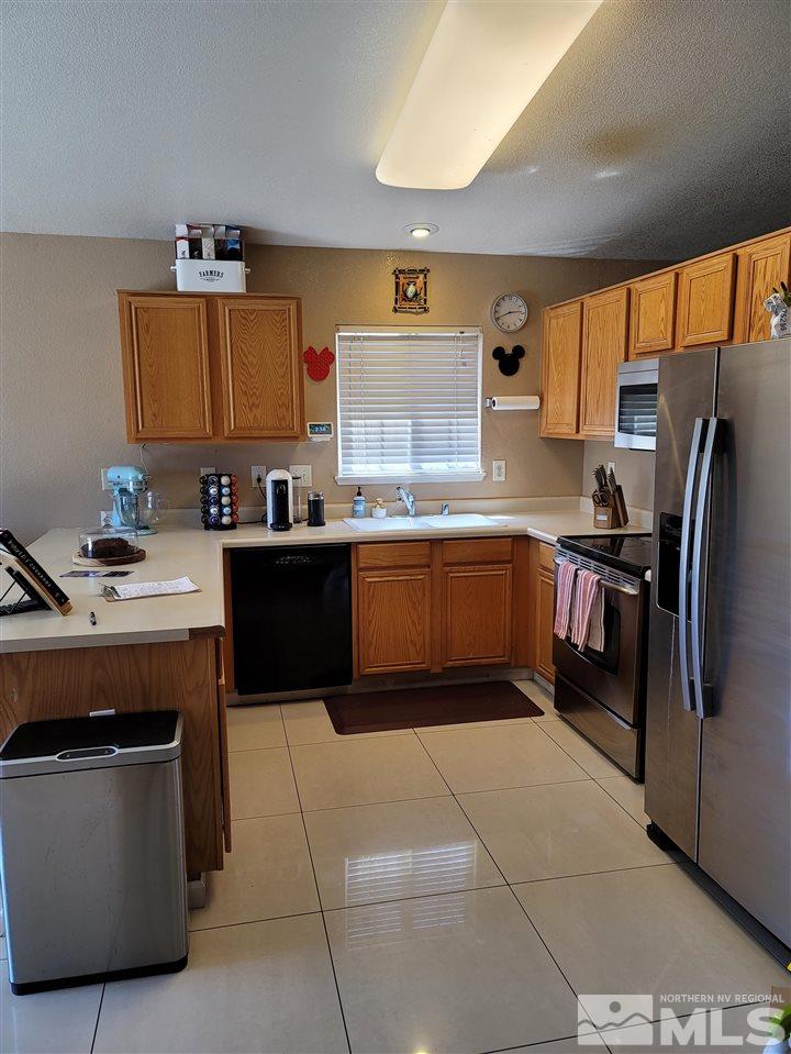 17756 Fortune Court Reno, NV 89508 - Photo 3 of 28 a kitchen with stainless steel appliances granite countertop a sink a stove and a refrigerator