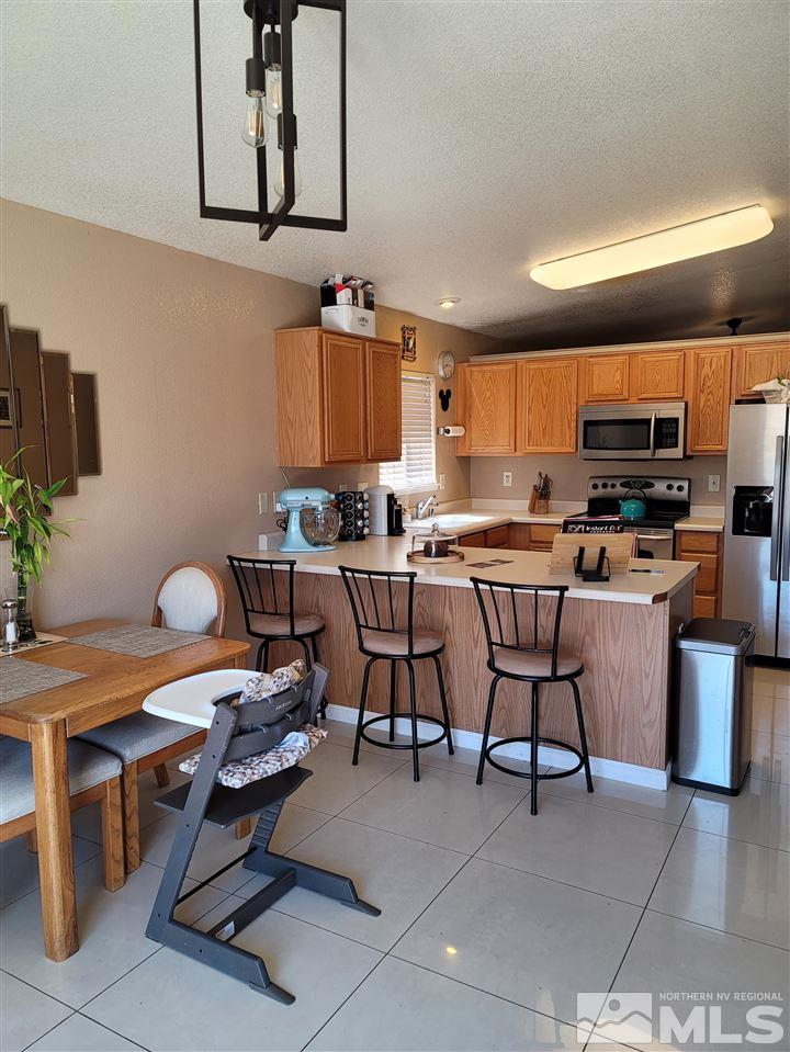 17756 Fortune Court Reno, NV 89508 - Photo 5 of 28 a room with stainless steel appliances kitchen island a table and chairs in it