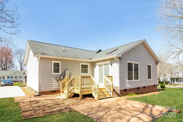a view of a house with backyard and sitting area