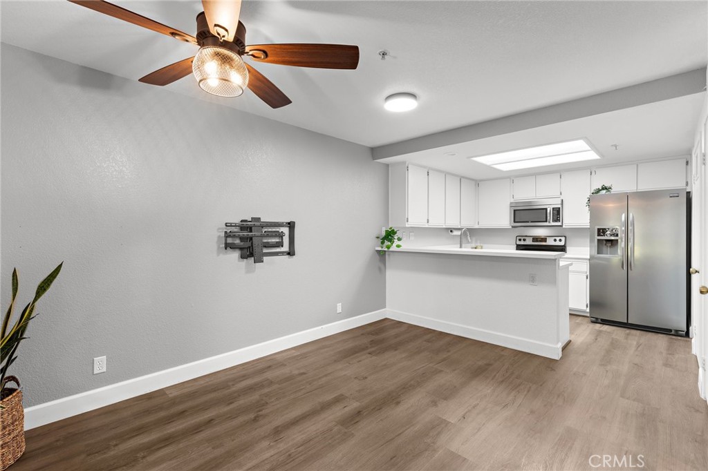 2800 Keller Drive, Unit 262 Tustin, CA 92782 - Photo 7 of 41 a view of kitchen with stainless steel appliances cabinets a wooden floor and a ceiling fan
