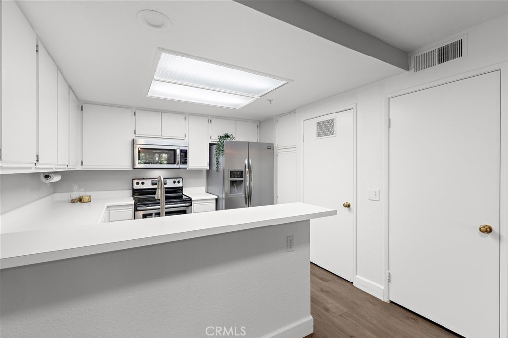 2800 Keller Drive, Unit 262 Tustin, CA 92782 - Photo 8 of 41 a kitchen with stainless steel appliances a refrigerator sink and microwave