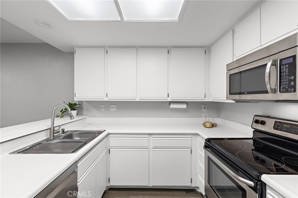 2800 Keller Drive, Unit 262 Tustin, CA 92782 - Photo 9 of 41 a kitchen with a sink stove and cabinets
