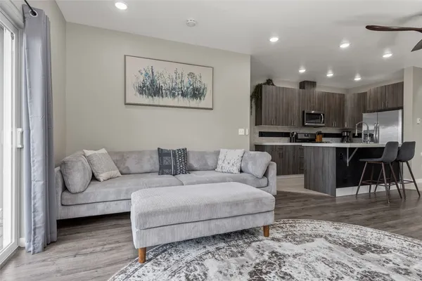 a living room with furniture and a dining table with kitchen view