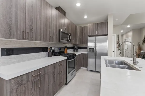 a kitchen with kitchen island a sink appliances and cabinets
