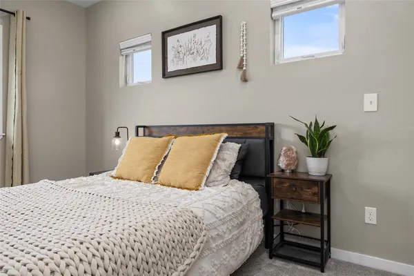 a bedroom with a bed and a potted plant