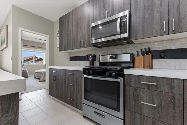 a kitchen with stainless steel appliances a stove microwave and cabinets