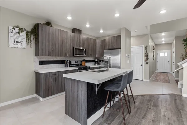 a kitchen with kitchen island a wooden floor and white appliances